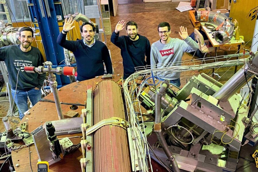 Rogerio's group waving next to a tokamak