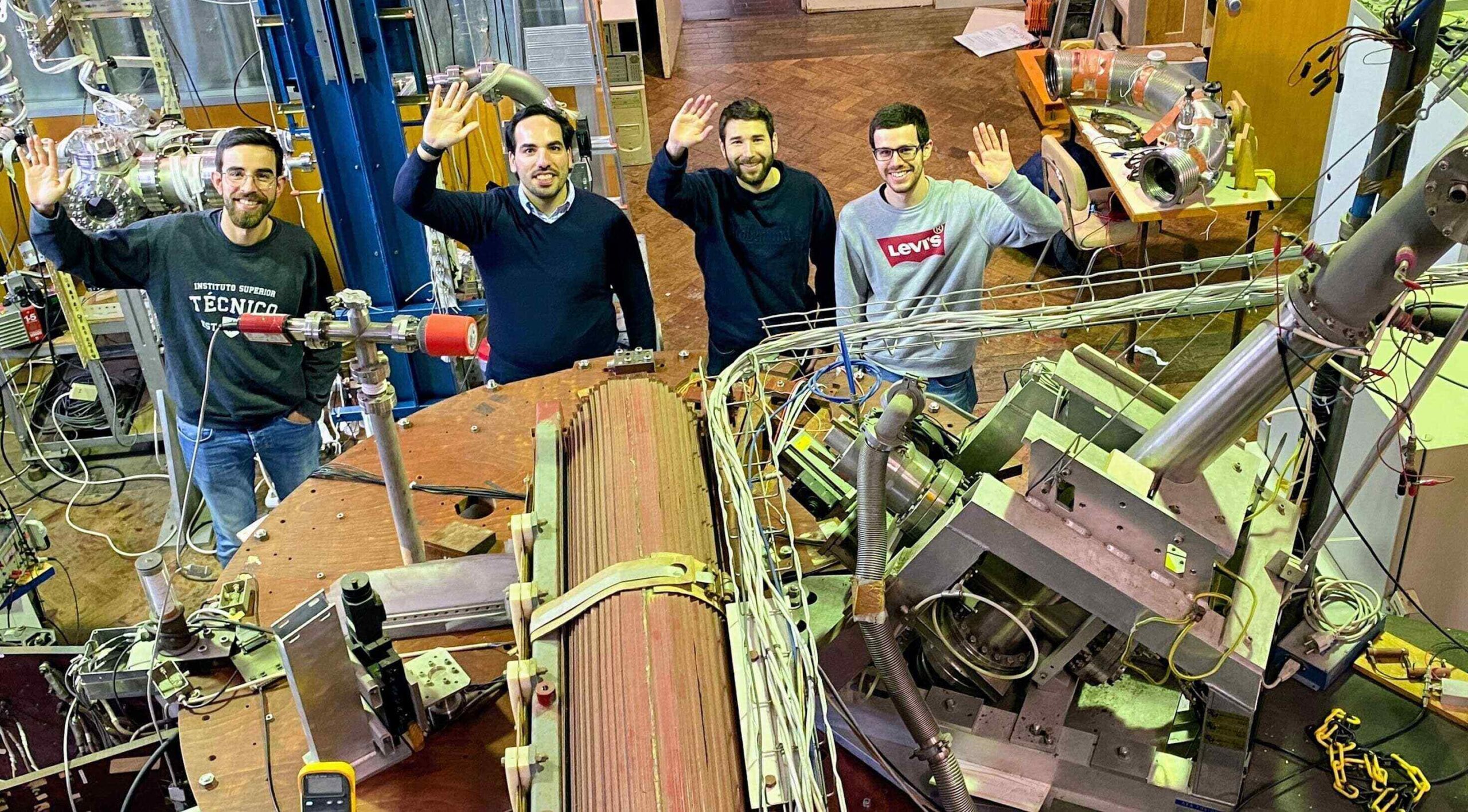 Rogerio's group waving next to a tokamak